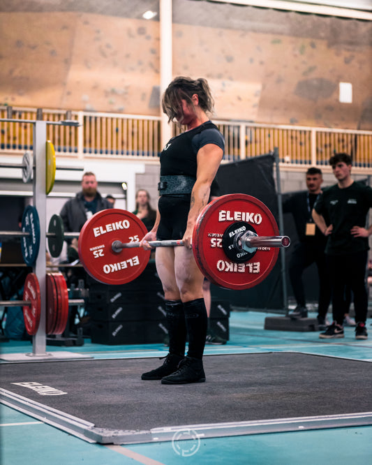 Woman doing a deadlift in a powerlifting competition. Eleiko powerlifting equipment. Odin Cup. Professional photography editing 